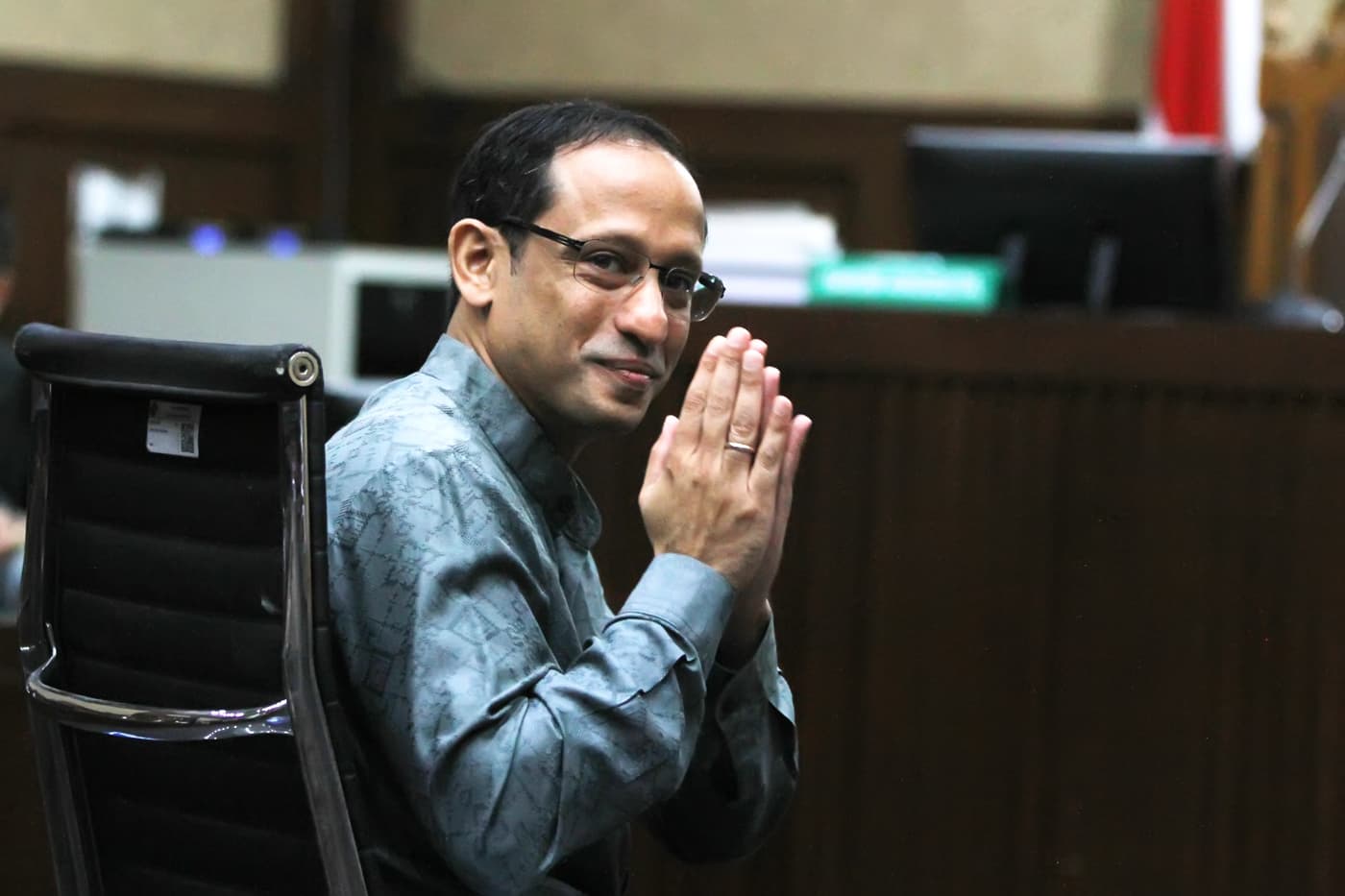 Tersangka kasus dugaan korupsi dalam digitalisasi pendidikan pengadaan laptop Chromebook di Kemendikbudristek tahun 2019-2022 Nadiem Makarim memberikan salam ke arah wartawan sebelum sidang pembacaan dakwaan di Pengadilan Tipikor, Jakarta, Senin (5/1/2026). (Dery Ridwansah/ JawaPos.com) - Image