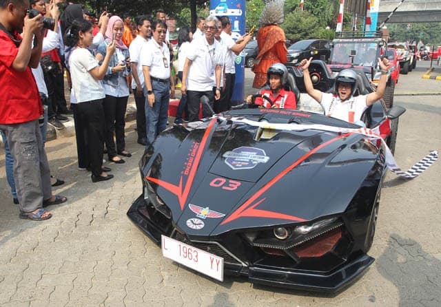 Direktur PLN Regional Jawa Bagian Barat Haryanto WS (kanan) menumpangi mobil listrik Lowo Ireng tiba di garis finish di gedung PLN Unit Induk Distribusi Jakarta Raya Jakarta, Selasa (3/9/2019). Usai menempuh jarak sekitar 900 kilometer dari Surabaya, Jawa - Image