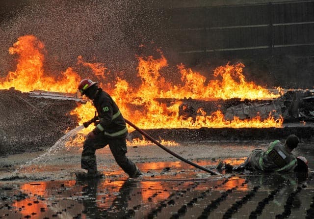 KEBAKARAN: Petugas pemadam kebakaran berusaha memadamkan api saat kebakaran pipa minyak milik PT. Pertamina di Melong, Kota Cimahi, Selasa, (22/10). PT.Pertamina masih melakukan invetigasi terkait kebakaran pipa milik pertamina tersebut yang terjadi di lo - Image