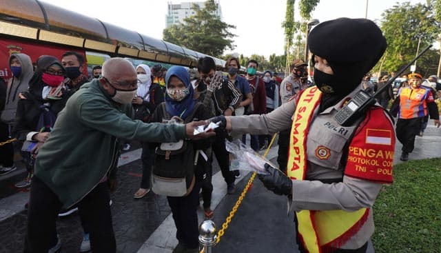 Petugas kepolisian melakukan sosialisasi protokol kesehatan, serta membagikan masker berwarna merah putih kepada masyarakat di Stasiun Tanah Abang, Jakarta, Kamis (27/8/2020). langkah ini dilakukan sebagai implementasi dari Instruksi Presiden Nomor 6 Tah - Image