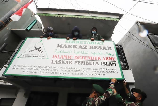 Aparat gabungan TNI dan POLRI mencopot atribut baliho Front Pembela Islam (FPI) di Kantor DPP FPI, Petamburan, Jakarta, Rabu (30/12/2020). Pemerintah secara resmi membubarkan FPI dan melarang segala aktivitas dan kegiatannya karena tidak memiliki keduduk - Image
