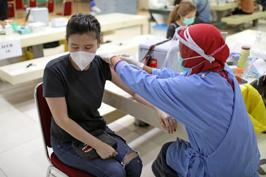 Petugas menyuntikan vaksin COVID-19 kepada pedagang di Blok A Pasar Tanah Abang, Jakarta, Kamis (18/2/2021). Kemenkes sejak Rabu (17/2) mulai menggelar vaksinasi bagi pedagang Pasar Tanah Abang. Sebanyak 9.729 pedagang mendapatkan jatah vaksinasi tahap pe - Image