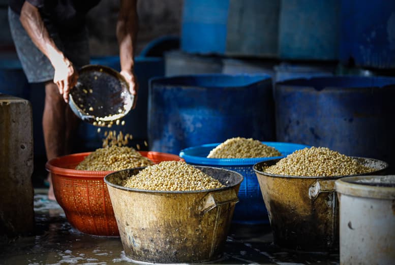 HARGA KEDELAI MEROKET: Sejumlah pengrajin memasak pesanan makanan tahu mentah dari pelanggan disat harga kedelai mengalami peningkatan yang cukup tinggi, kemarin, Kamis (20/1/2022). Harga kedelai melonjak tinggi dibulan Desember 2021 hingga awal tahun 202 - Image